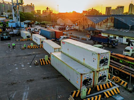 Refrigerated container handling at Dar es Salaam terminal with trucks, yard equipment, and operational staff