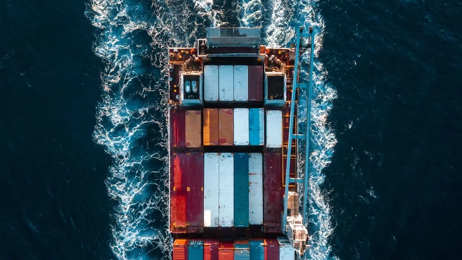Top-down view of a cargo ship navigating through a DP World-managed waterway