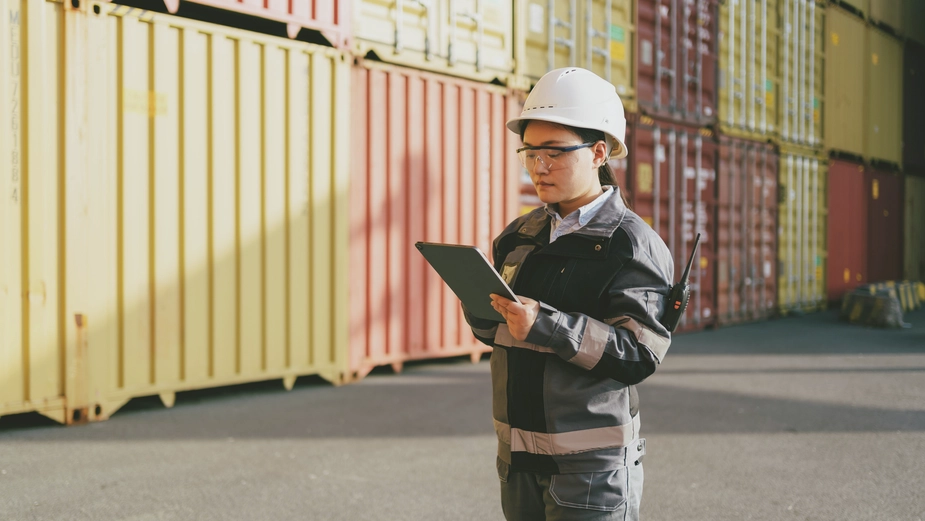 Female port worker inspecting containers
