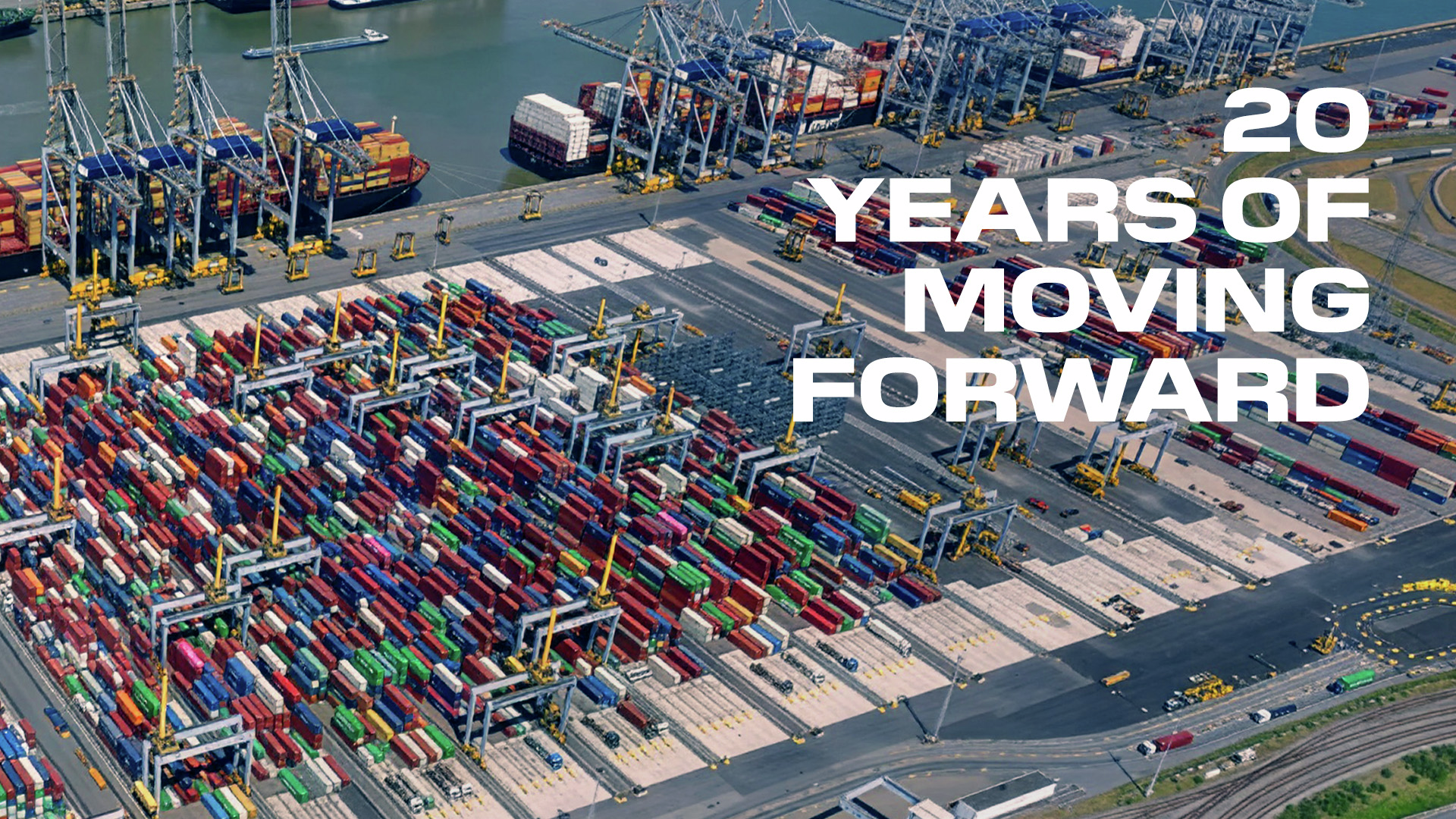 Aerial view of a busy port terminal with stacked shipping containers and the text “20 Years of Moving Forward”.
