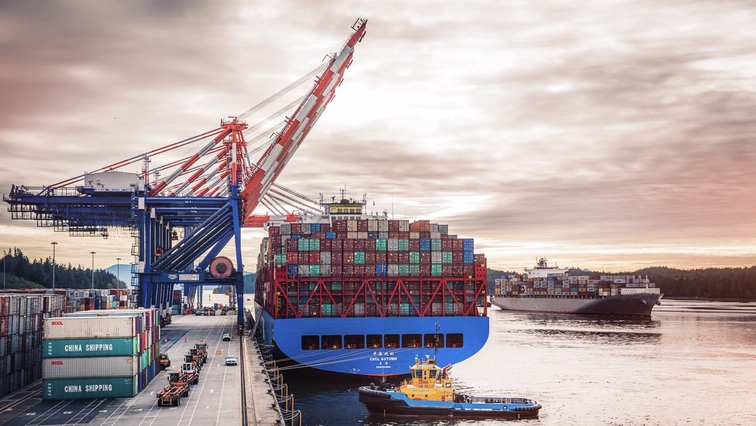 Two vessels docked with a tug boat at Prince Rupert port during sunset, featuring DP World containers.